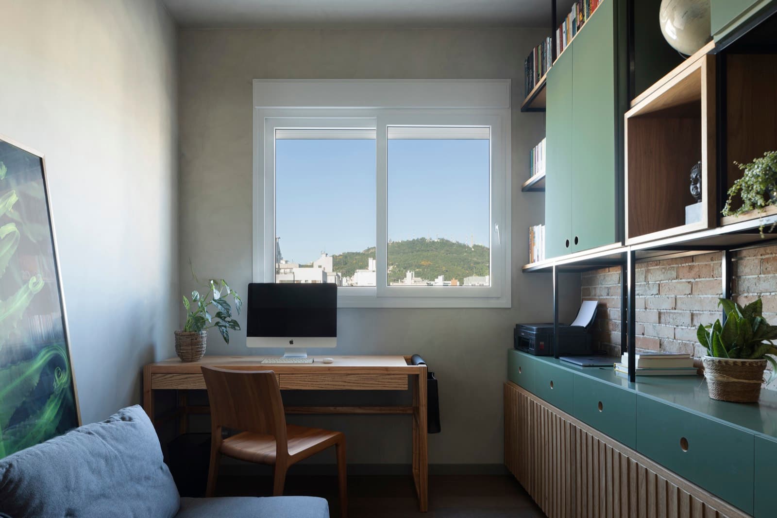 Home office com bancada de trabalho e vista para a cidade