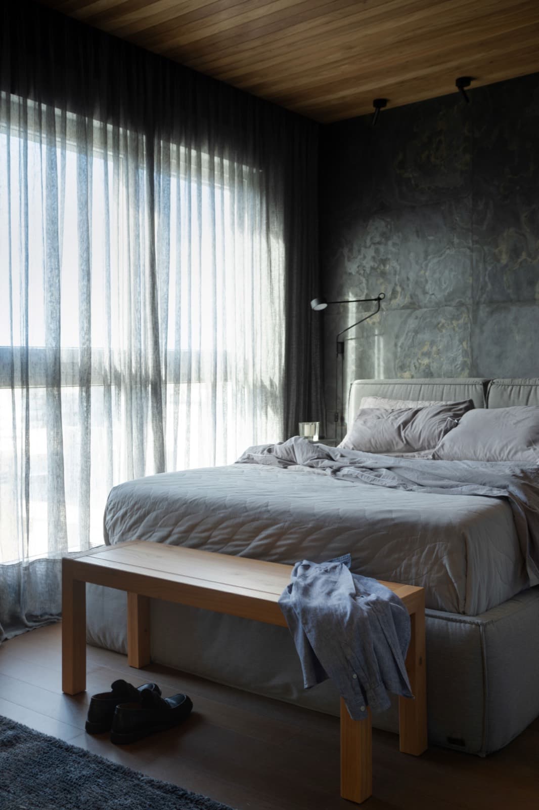 Suíte com banco de madeira ao pé da cama