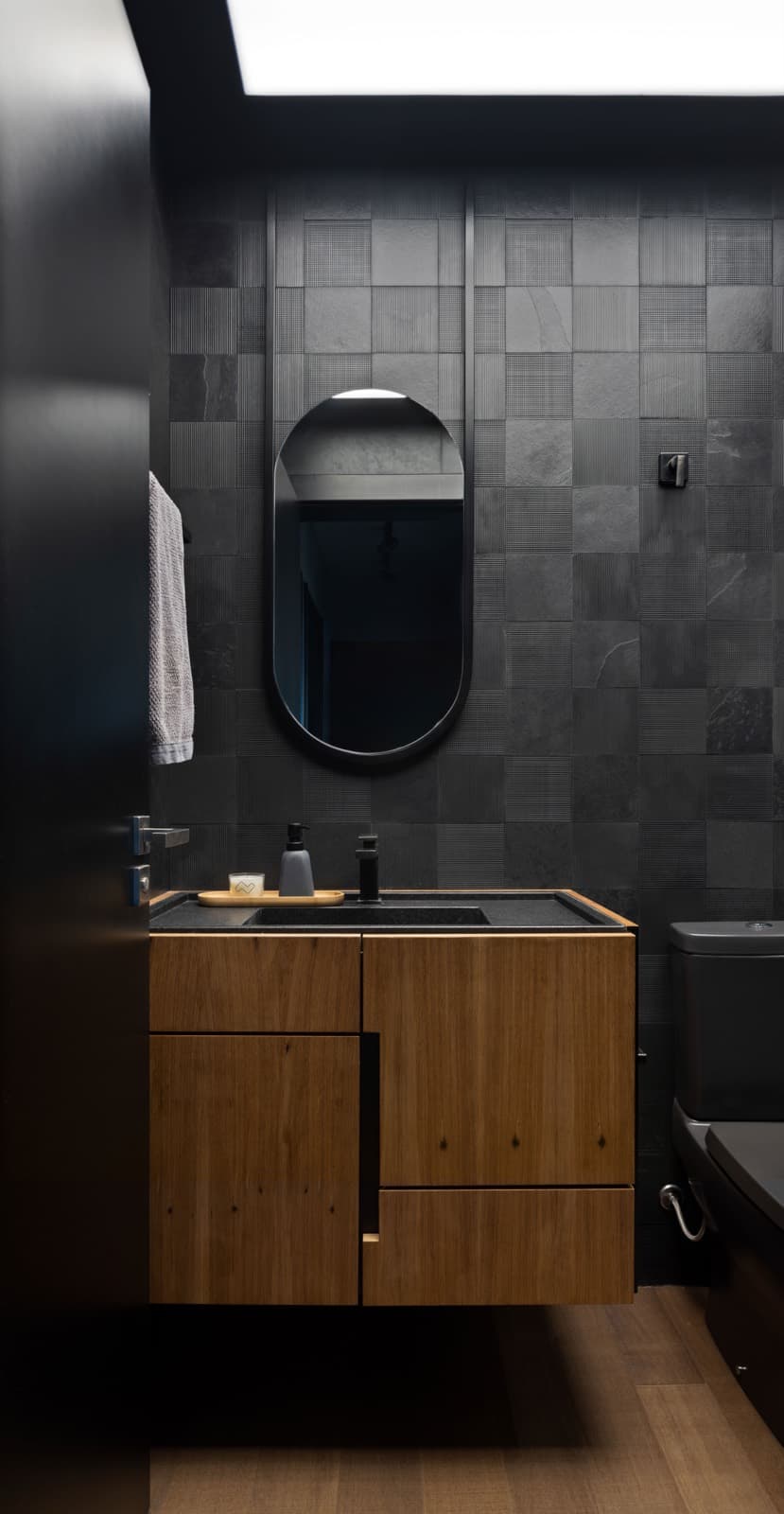 Lavabo escuro com gabinete de madeira suspenso
