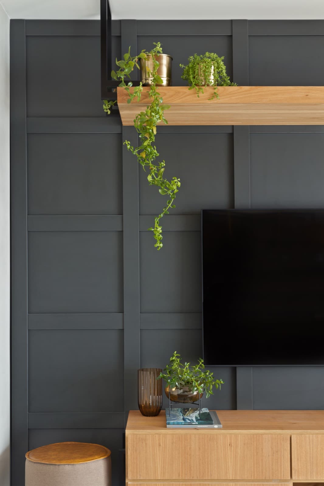 Painel de TV em boiserie preta com prateleira de madeira