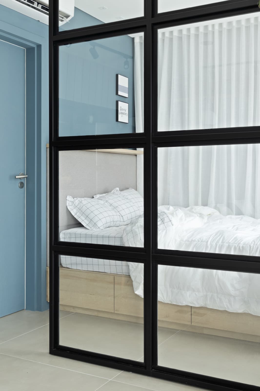 Divisória de vidro preta entre sala e dormitório