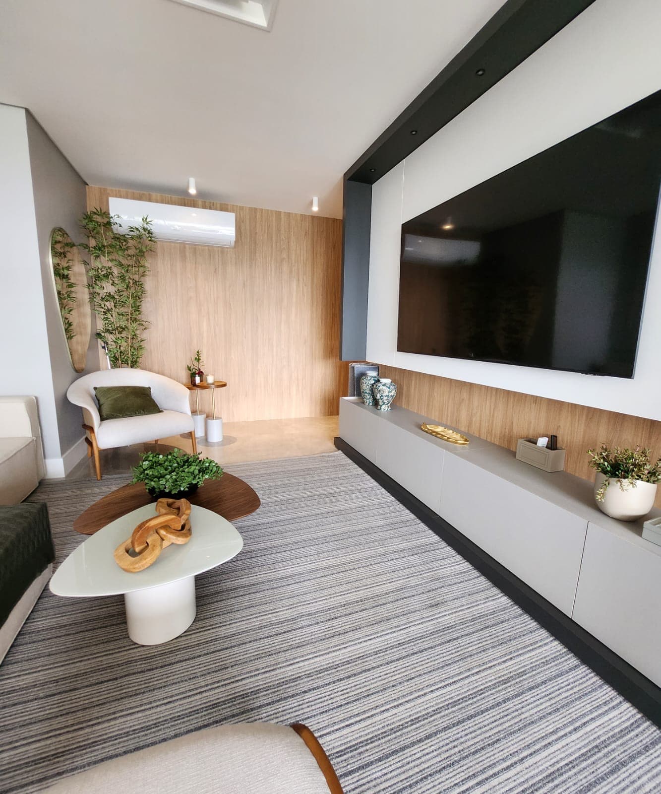 Sala de estar com poltrona e painel de TV