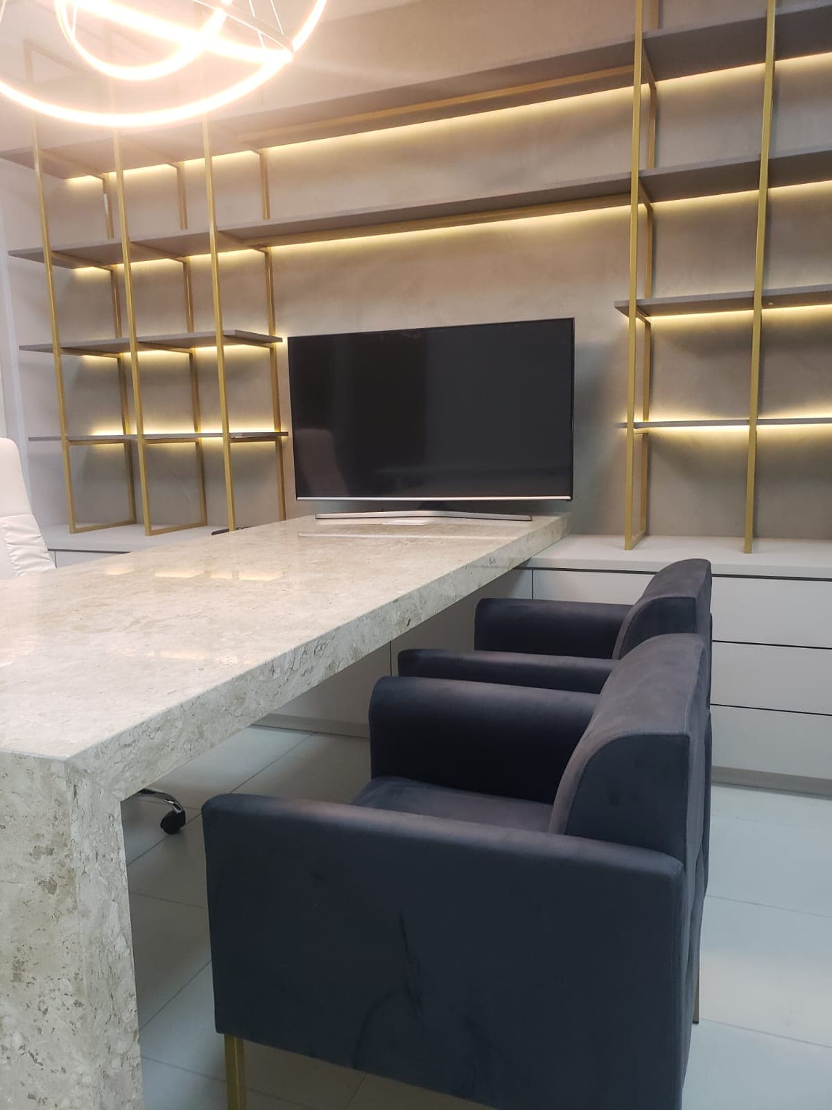 Sala de reunião com poltronas e bancada de mármore