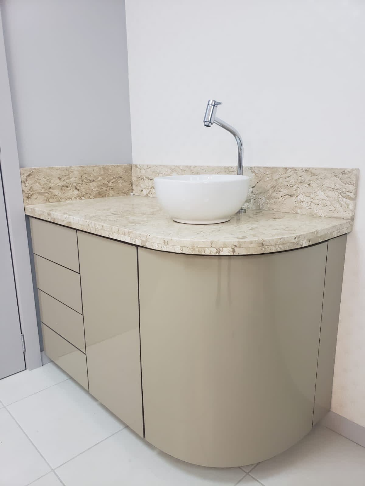 Lavabo com gabinete curvo e bancada de pedra