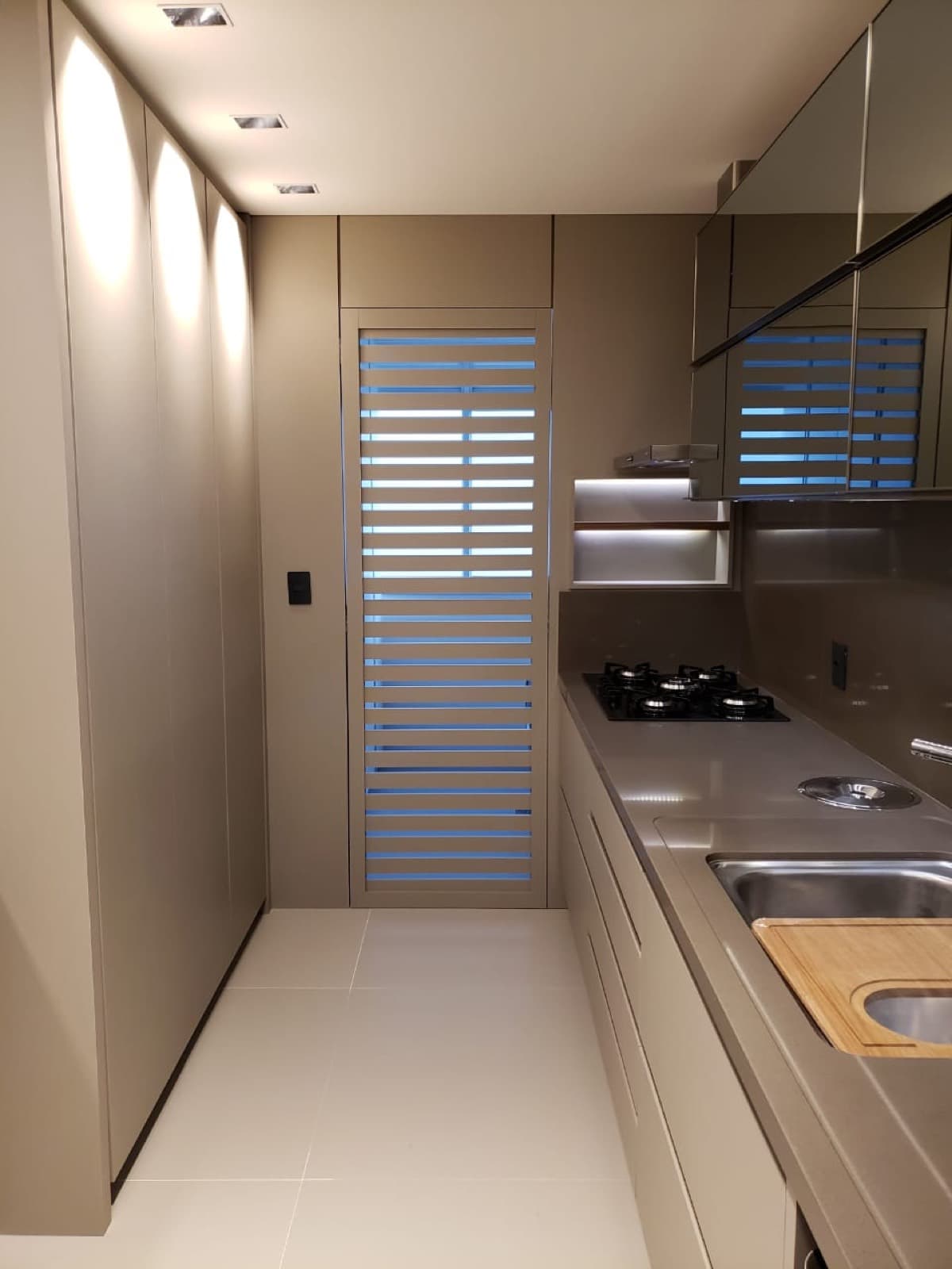 Cozinha em corredor com armários até o teto