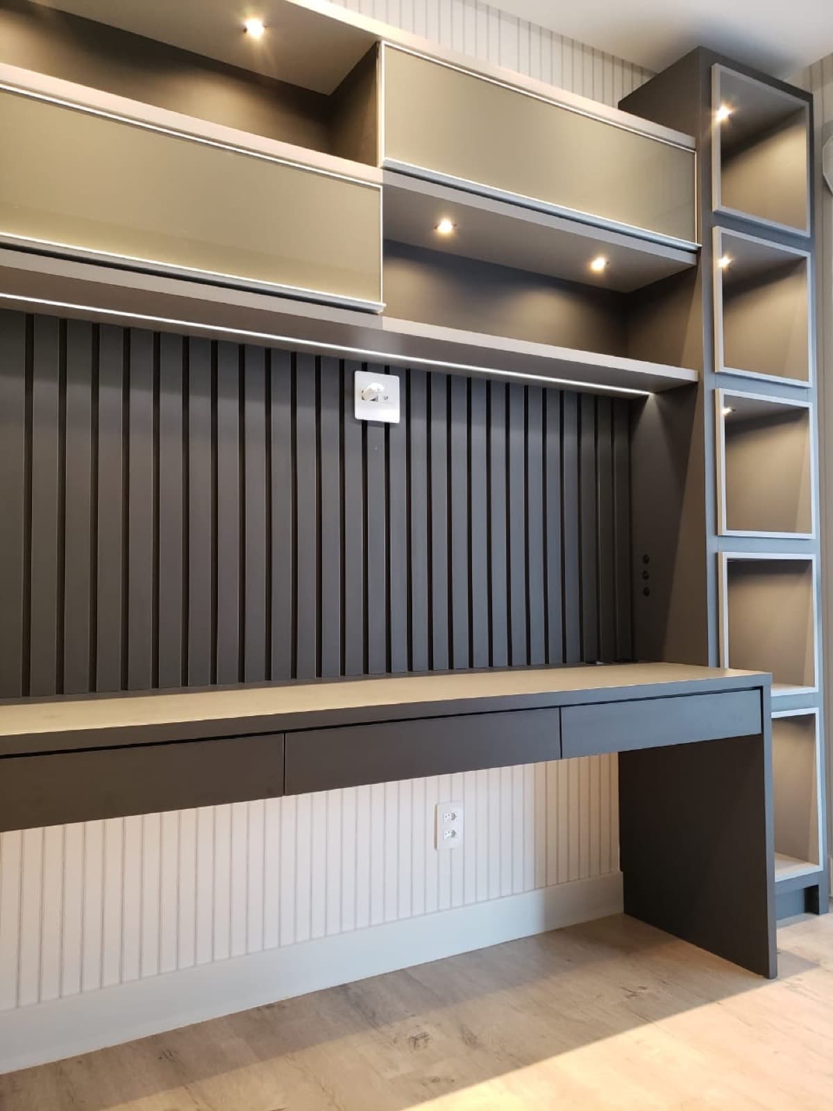 Home office com bancada suspensa e painel ripado
