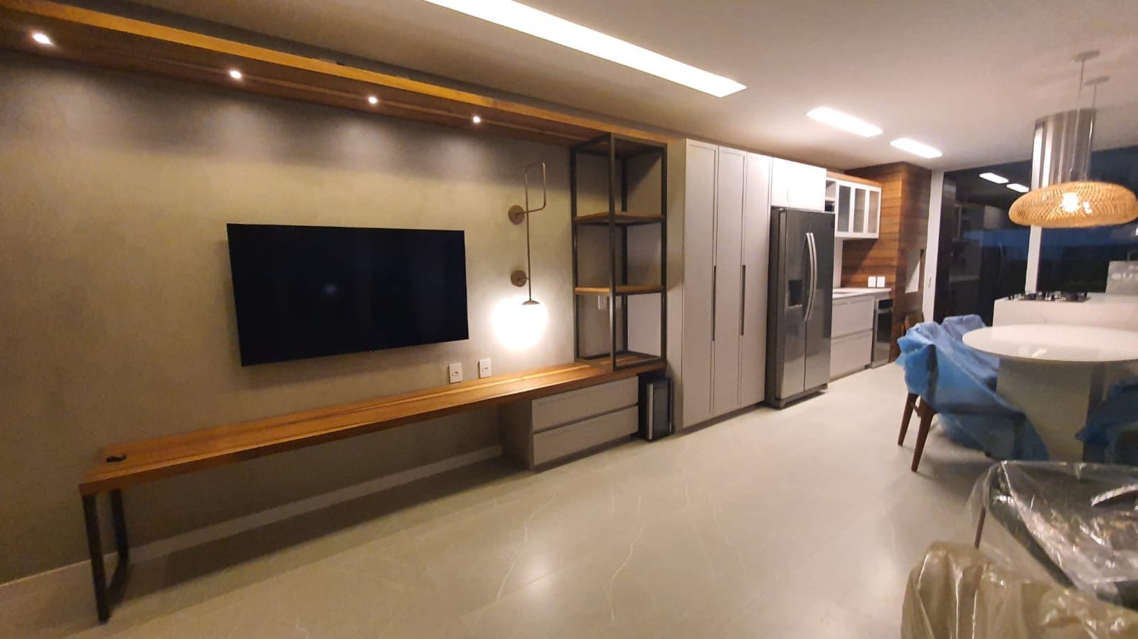 Sala de estar com bancada de madeira maciça e estante metálica