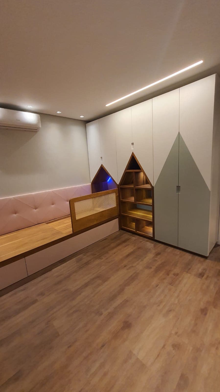 Quarto infantil com banco estofado e armários casinha
